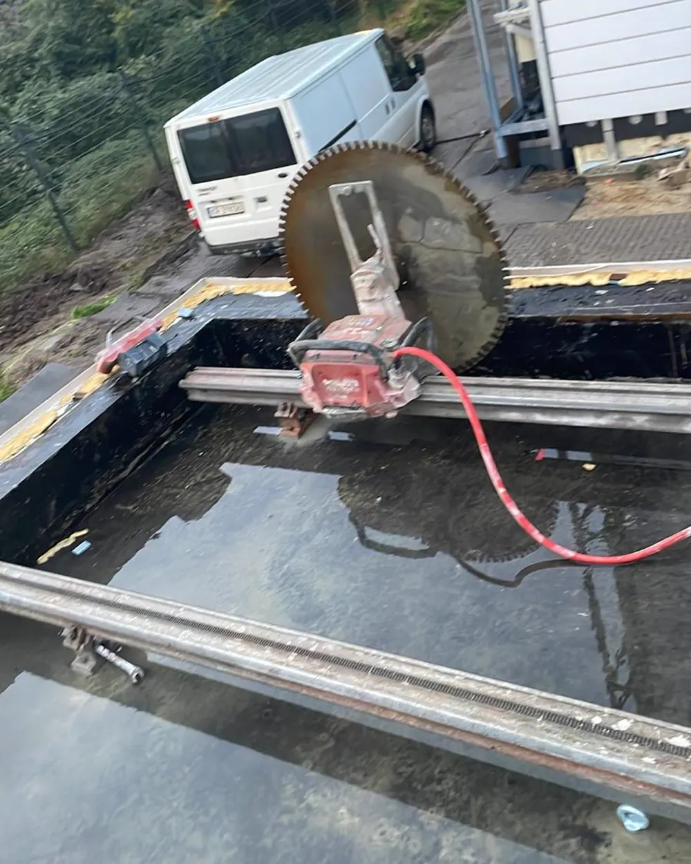 Piła z dużą tarczą diamentową tnąca żelbetowy strop na otwartej przestrzeni