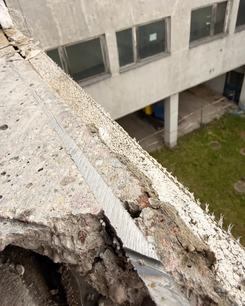 Widok z góry na wycięty betonowy parapet — wąska szczelina po tarczy i prosta krawędź cięcia wzdłuż całej długości