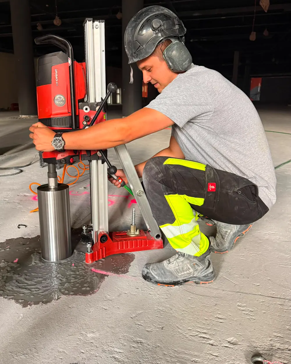 Operator KFDIAMENT obsługuje wiertnicę rdzeniową Hilti na stojaku kotwionym do betonowej posadzki